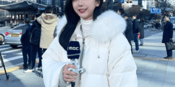 a woman in a white coat holding a microphone